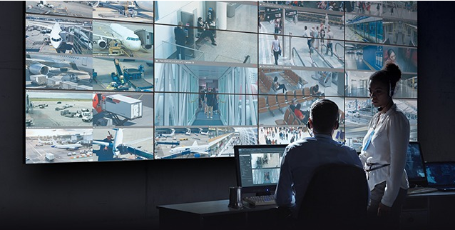 A man sitting at his desk in front of multiple monitors.